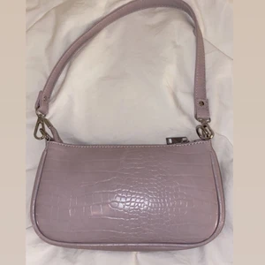 Väska från Ginatricot  - En jättefin beige/rosa axelväska från Ginatricot!💗 Helt ny,aldrig använd💗 Ett stort fack och ett mindre fack med blixtlås💗🎀 Vanlig storlek på axelväska (jämförelse med mobil på sista bilden)💗 Köparen står för frakten💗