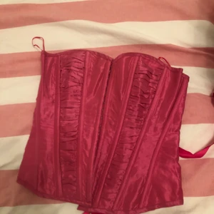 Korsett topp - Korsett topp med snöring bak, formad i brösten med knäpp fram. Endast använd 3-5 ggr så nästan som ny med inga slitage