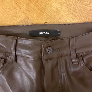 Bruna skinnbyxor från Bikbok  - Bruna skinnbyxor från Bikbok. Köpta i slutet av sommaren och är sedan dess använda ett få tal gånger, och är därför i perfelt skick. Köpta för 500 kr, tror de är slutsålda. Skriv till mig för fler bilder💕