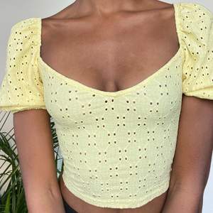 A yellow tight fitted crop top with fluffy sleeves. The holes are cut outs but the shirt I’m not see through at all. Covers everything even if worn without a bra. The top is really tight for me and fits almost as a corsets. Super cute otherwise. 