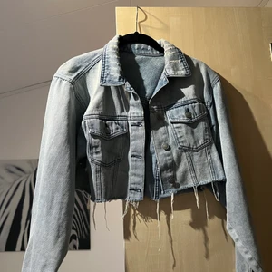 Kortare jeansjacka - Från NA-KD i ljus jeansfärg och slitningar! Passar en XS-S. Supersnygg på sommaren över en klänning!! 