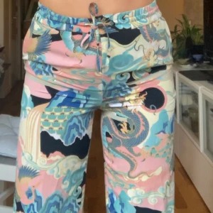 Byxor med drakmotiv - Säljer mina favoritbyxor som tyvärr blivit lite små! De är jättesomriga och är i ett lite mer slitsstarkt kostymbyxmaterial, och funkar både till vardags och att klä upp! De är i gott skick och passar i längden för den som är ca 1,65!❤️ hör av er om ni har frågor