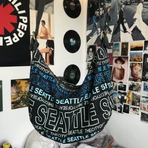 Axelväska  - En jättesnygg väska från Robin Ruth med texten: ”SEATTLE” & ”THECITYOFSEATTLE”                           Höjd: 15cm Bredd: 23cm Djup: 8cm                          Frakt tillkommer📦