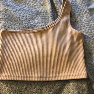 Topp - Beige oneshoulder-topp. Säljer då den aldrig används!