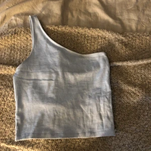 Topp - Ljusblå oneshoulder topp i strl s/xs