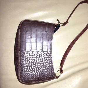 Axelremväska - Säljer denna snygga axelremsväska i färgen mörk brun. Nästan som ny köpte använd 1 gång. Säljes pga kommer ej till användning 