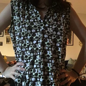 70-tals mönstrad blus/väst  - Väldigt mysig blus/väst med grönt och brunt 70-tals mönster! Passar väldigt fint med en svart tröja under, tycker jag. Inte använd så mycket och har mest legat i garderoben. 