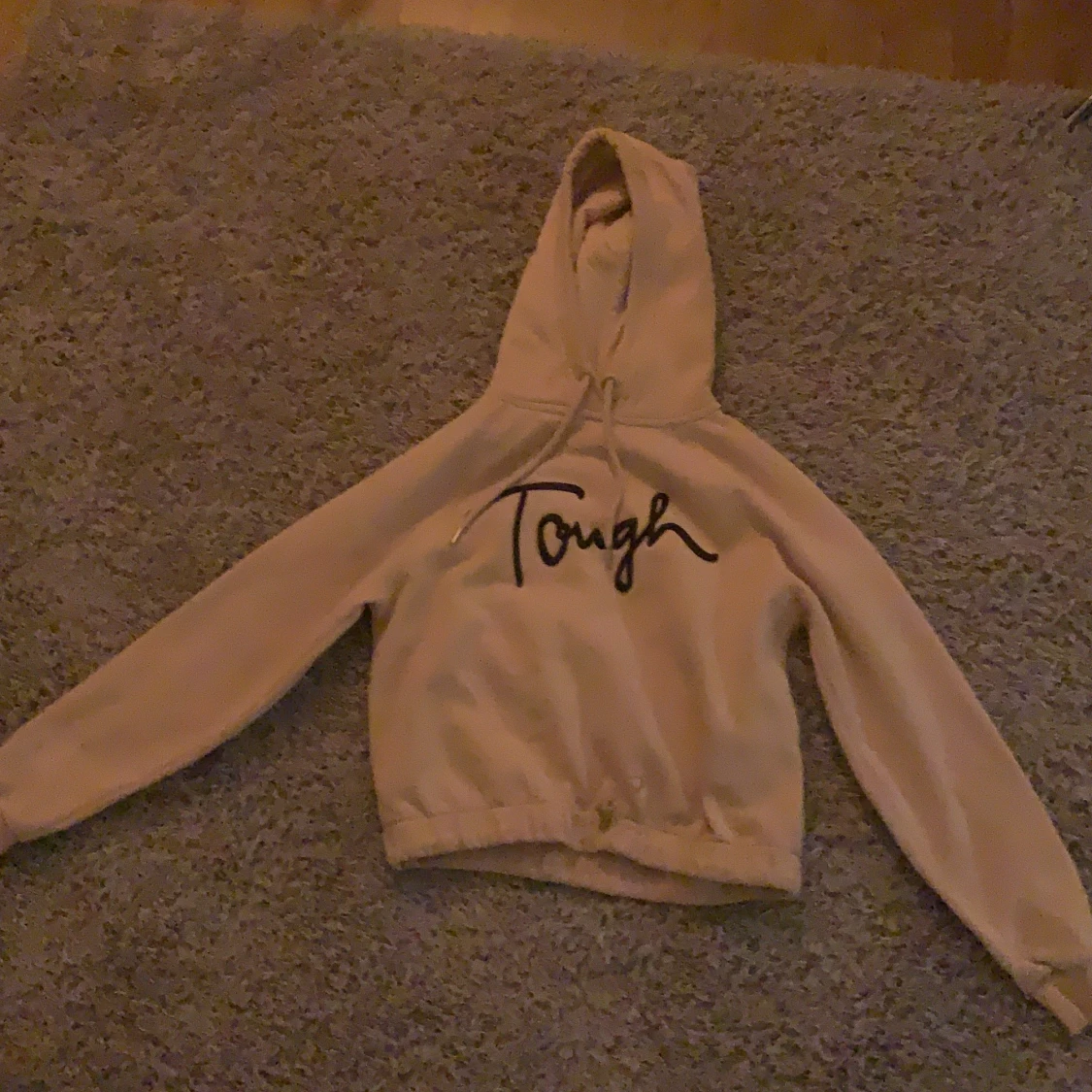 En beige Hoodie med svart text på - 90