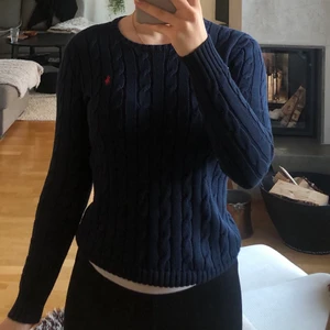 Ralph Lauren kabelstickad  - Jättesnygg kabelstickad tröja från Polo Ralph Lauren i stl xs. Sitter jättebra! Marinblå med rött märke. Lagat hål på ryggen, inget som syns. Nypris 1500kr säljer för 200kr.