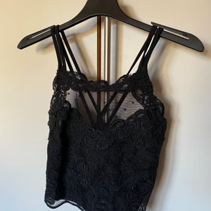 Svart topp - As snygg topp från River Island i storlek 8, skulle gissa på att det kan motsvara XS/S. Köpt för ett par år sedan men inte kommit till användning alls mycket. Frakt på 52kr tillkommer och spårbart 66kr.