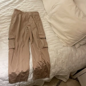 Guldiga/ beiga byxor från Zara - Använd ett fåtal gånger och i nyskick. Ska egentligen stylas med ett  skärp. Har fler bilder. Passar mig som är 163cm
