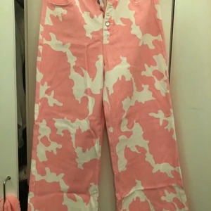 Cow print rosa jeans, Wide leg Strl L - Supersköna jeans med rosa ko fläckar, de är wide leg, säljer dessa för att de inte satt så fint på min kropp, de är använda 1 gång.