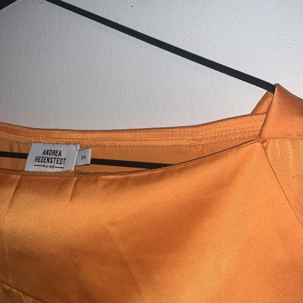 Orange satinblus från NA-KDS kollektion med Andrea Hedenstedt. Blusen är i storlek 34 och sitter väldigt fint över ena axeln🌼🌼. Blusar.