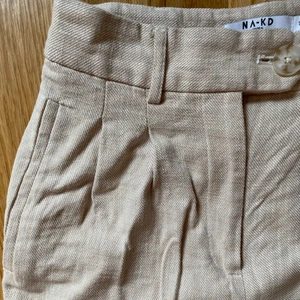 Byxor i linneimitation  - Byxorna är i storlek 34, och är från NA-KD. Använt 2 ggr, så de är i väldigt gott skick! 