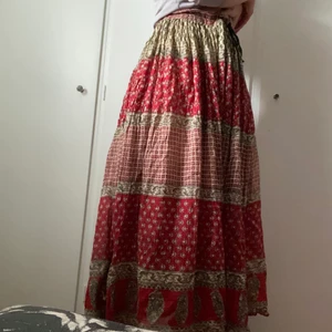Mönstrad kjol - Kjol med röda , beiga och gröna mönster på. Ganska lång och väldigt skönt material. Storlek är oklart men det går att anpassa väldigt bra i midjan så jag tror den skulle passa dom flesta. ❤️ Har dock ett hål längst ner!! Men det syns väldigt lite då kjolen har så mycket tyg, jag märkte det inte alls först.