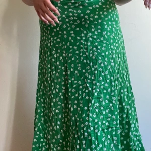 Grön blommig kjol  - Grön kjol med vita små blommor på andvönt fåtal gånger med dragkedja vid sidan! 