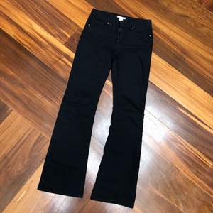 Black bootcut trousers with low/mid waist. Soft denim fabric.