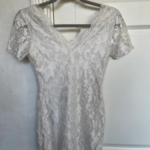 Figursydd vit spetsklänning  - Figursydd vit spetsklänning i fint skick, endast använd få gånger. Storlek 12, skulle säga att den sitter som en xs/s