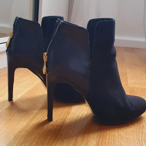 Ankelboots från Zara med guld detalj - Snygga svarta ankelboots från Zara I storlek 37. Har använt ett par gånger men skorna är i god skick. Pris kan diskuteras. 