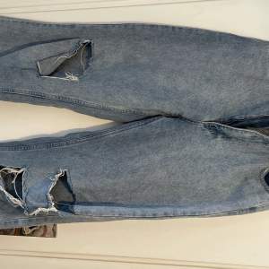 Höga jeans som är vida i benen med hål och slitningar. Knappt använda i fint skick