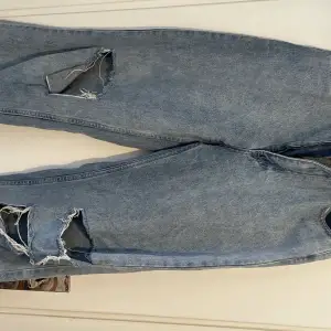 Höga jeans som är vida i benen med hål och slitningar. Knappt använda i fint skick