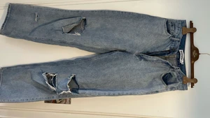 Ljusa slitna höga jeans - Höga jeans som är vida i benen med hål och slitningar. Knappt använda i fint skick