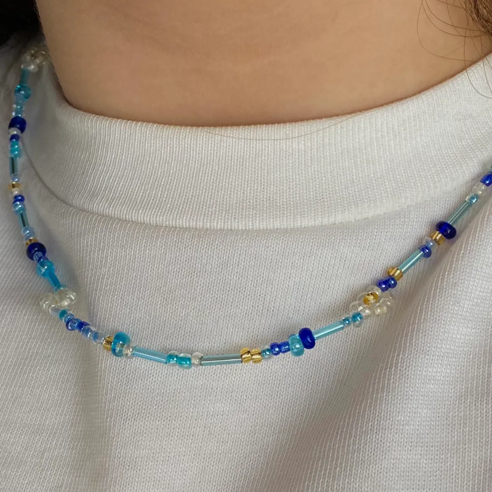 Ett gulligt halsband med blommor i och blåa pärlor av olika slag. Finns att köpa för 55kr💙⚡️. Accessoarer.