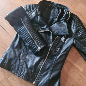 Skinnjacka från märket Primeboots  - Säljer denna mkt sparsamt använda skinnjacka i stl. 34 från Märket Primeboots. Den är i äkta skinn, Svart med silvriga dragkedjor. Skinnet är mkt mjukt och följsamt , eftersom att den är så lite använd så har skinnet inte hunnit forma sig än, Så den kommer att forma sig efter just din kropp (du som köper den!) Jackan är köpt i en butik i Göteborg för 3500kr  Säljs för 1000 kr prutat och klart vilket är ett  väldigt bra pris för denna jacka som är så lite använd och kan användas i flera år framöver då äkta skinn bara blir finare med åren ju mer den används.