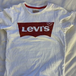 Riktig Levis T-shirt  - Tröjan är i bra skick förutom att den har en liten fläck nedanför den här rutan där det står lives men ni kan se fläckarna på bild 2. Riktig Lives. Säljer pågrund av att den är för liten får precis på mig den men den sitter jätte trångt och i sommar kommer det vara alldeles för liten så säljer därför.☺️  jag är inte 100% på storlek men jag tror att den 128 eller 132 nån stans där så passar nog till 9-10 kanske 8 och 11 också. Köparen står för 30kr frakt 🚚📦