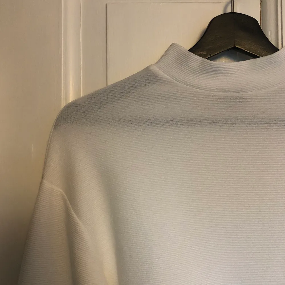 Jättefin vit tröja med knyte i ryggen från Gina Tricot. Den är i storlek XXS men funkar även för XS och S (något kort i ärmarna dock). Knappt använd så i mycket fint skick. Köparen står för frakten! . T-shirts.