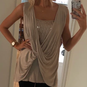Festlig topp beige  - Beige topp med paljetter från Vero Moda.