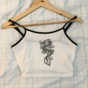 drak-linne  - ett vitt linne från SHEIN med en svart drake tryckt på. Linnet är SÅÅ skönt😍😋 linnen är inte min stil riktigt, jag föredrar t shirts, så jag säljer denna.💖 den är XS men passar mig, S, och skulle mest troligt passa M. Otroligt skön och stretchig 