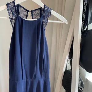 Byxdress - Marinblå byxdress från Nelly. Endast använd en gång. Långa vida ben och öppen rygg. 