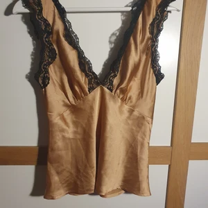 Topp från Asos - Jättesöt top från asos! Använd 1 gång. Relativt liten i bysten. Knytning i bak. Färgen är svår att få med på bild, så fråga gärna om du vill se mer bilder! 