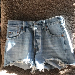 Jeans shorts från Levis modell 501 - Säljer dessa blå jeansshorts i modellen 501 från Levis. De är storlek W23, säljs pga att jag gått upp i storlek. De är använda fåtal gånger. Köpta för 500kr. Startbud 200kr