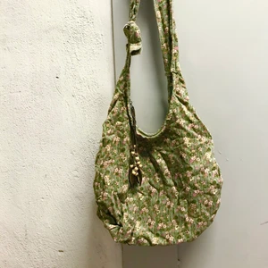 Grön väska med blommor, pärlor, manchester  - Superfin väska i något slag manchestertyg och prydd med blommor och löv i trä vid dragkedjan. Rymlig och med innerfack! Sista bilden representerar färgen bäst. Kan mötas i Stockholm eller skicka mot fraktkostnad! ✨🌸✨