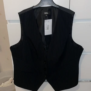 Väst - Svart väst från Marks & Spencer, storlek 38! Aldrig använd utan bara testad. Svin snyyyggggg till kostymbyxor. Säljer pga för stor. Går att reglera storlek lite där bak. Köparen står för frakt! Säljs inte längre men nu kostar ca 600kr