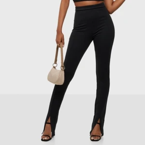 Byxor  - Svarta byxor med utsvänga ben,slits nere vid foten, st XS ( Förstabild lånad )