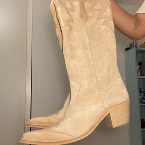 Mockacowboyskor beige  - Säljer mina unika och svinsnygga mockacowboyskor i beige med skinndetaljer pga att de var för stora:( Köpta vintage från Zara i storlek 40. Jättefräscha och i bra skick men är lite använda på sulan. De är lite kallare beige i verkligheten. Frakt ingår ej. DM:a för fler bilder/frågor💖💖
