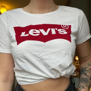 Vit Levis t-shirt med rött tryck - Äkta Levis t-shirt. Strl M. Fick i studentpresent och har använt den max 3 ggr på de 4 åren. Jättebra skick, bara lite skrynklig ;). 