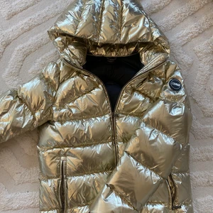 Guldig dunjacka!  - Superfin guldig dunjacka från colmar. Finns inte att få tag på längre. Endast använd två gånger under en skidresa. Passar xs-s. Nypris var 5000kr 