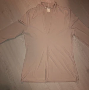 Beige tröja  - Beige tröja som passar både till fest och vardag med sin urringning. Storlek M. Från H&M.
