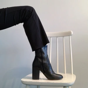 Klassiska sockboots i konstläder  - Klassiska sockboots i konstläder från Asos. Strl 38, klack 8 cm längd på innersula (från tå till häl) 24 cm. Ganska smala i foten. Använda ett fåtal gånger utomhus så har måttliga slitning på undersula, lite sprucken i lädret vid ankelresåren annars i fint skick. Frakt 66 kr.