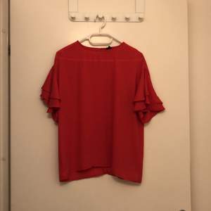 Röd kortärmad t- shirt med volanger. Från Ginatricot, storlek 34/ xs. Kostar 30kr, köparen får stå för frakten 
