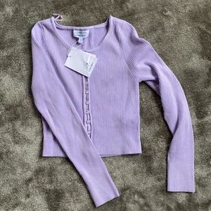 Oanvänd söt kofta - Lila söt kofta från & Other stories. Tror inte det är meningen att man ska kunna knäppa upp knapparna. Nypris är 490. Helt oanvänd. Köparen står för frakten.