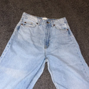Hm jeans - Ett par helt nya ljusblåa jeans från hm, ej använda. Hög midja och väldigt vida i benen. Säljer pga för vida ben och för tighta i midjan. Byxorna är som slim i midjan och har även lite slitningar längst ner på benen.  Nypris 299kr.