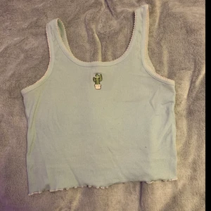 Linne croppat - Ett pastellblått linne med en gullig kaktus brodyr. Linnet har även ljusrosa ”lettucesöm” 🥰