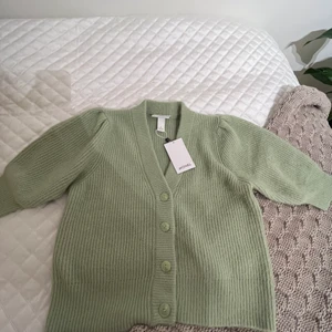 Grön kofta från Monki - Säljer den här gröna koftan från monki (puffärmar), aldrig använd, beställde hem den för ett par år sedan, men passade inte i den, men orkade inte lämna tillbaka den.. Den är i nyskick och jag köpte den för 300kr. 💕 Köparen står för frakt. 