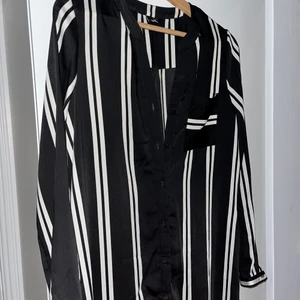 Randig blus  - Lång, luftig blus från Vero Moda. Når mig (167cm) till vaderna och med en 40cm (ca) slits vid var sida. Knappar hela vägen så kan användas öppen eller stängd. Är stl M med passar mig som är stl S alldeles perfekt