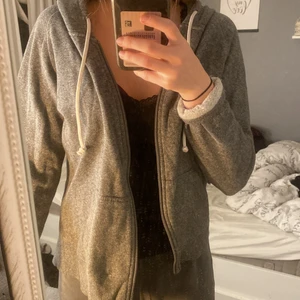 Zip grå hoodie i strl M från Cubus  - En vanlig grä zip hoodie med vita snören i strl M från Cubus. Rätt så använd, men är fortfarande i bra skick och kvalitet. 
